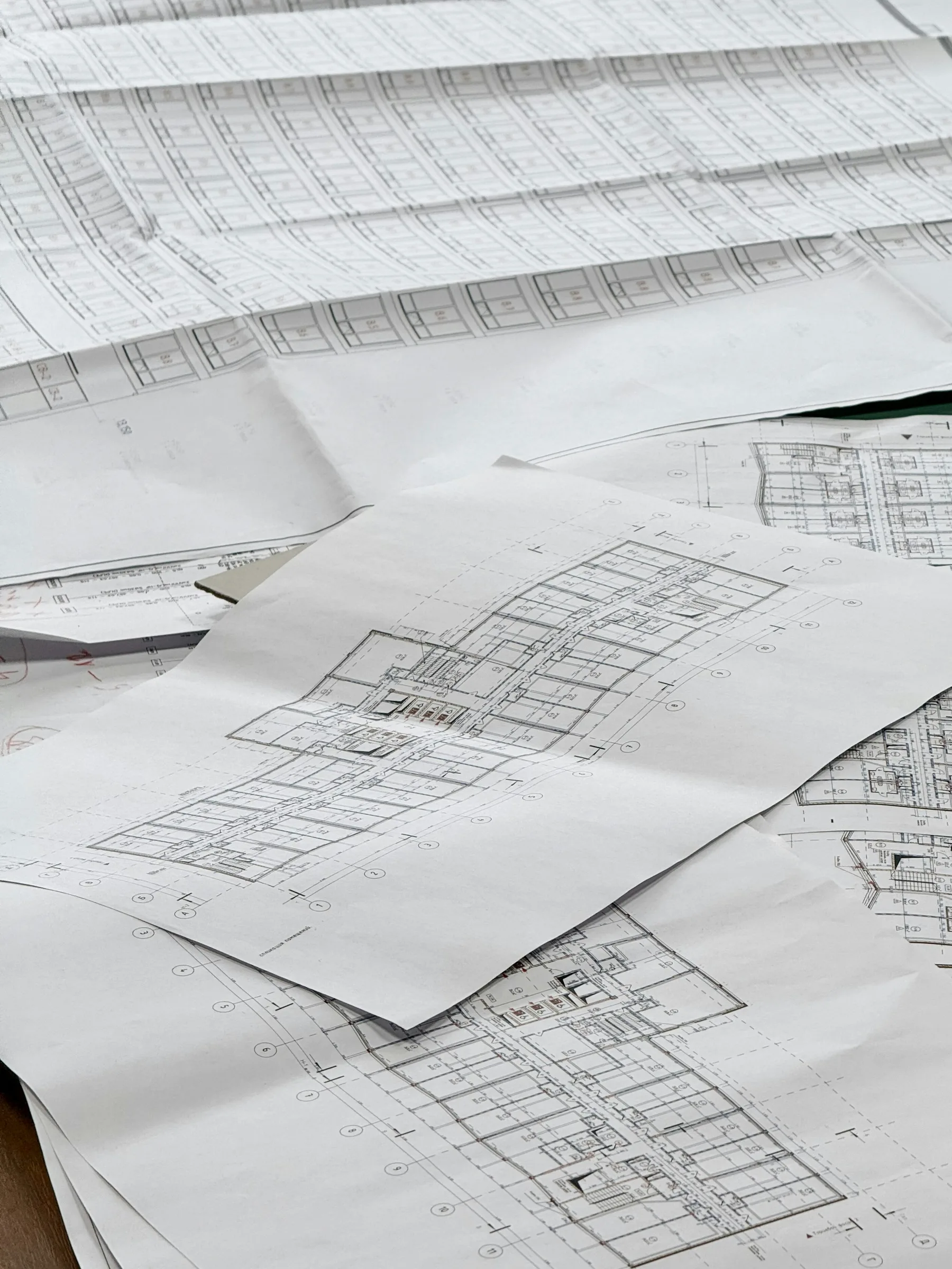 Illustrative construction plan sheets spread across a table